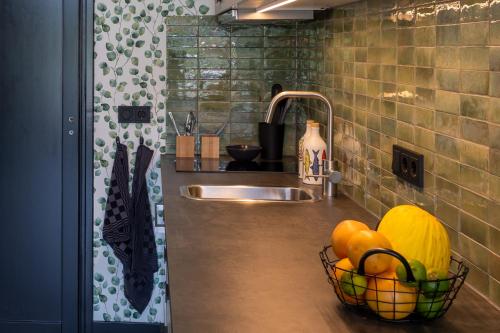 - un comptoir de cuisine avec évier et une corbeille de fruits dans l'établissement Bed & keuken De Vos, à Delden