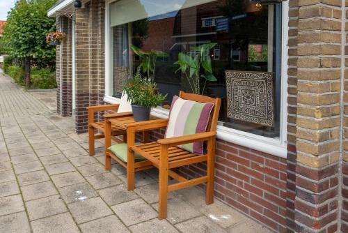 two chairs sitting outside of a store window at Bed & keuken De Vos in Delden