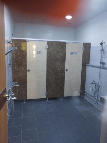 a row of four bathroom stalls in a room at T stay pension in Cheongju