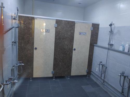 a bathroom with three stall stalls in a room at T stay pension in Cheongju