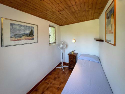 a small room with a bed and a fan at Azienda Agricola Sapereta in Porto Azzurro
