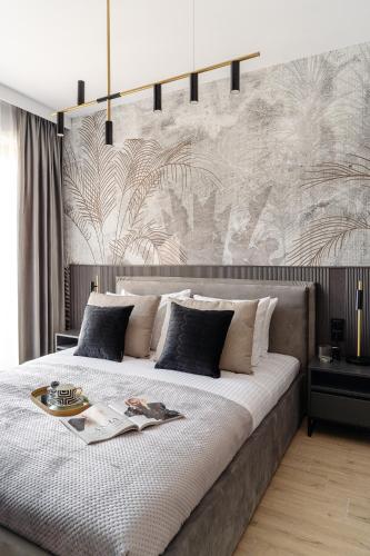 a bedroom with a large bed with a wall at Muse - LoftAffair Spa Collection in Kraków
