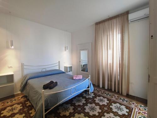 a bedroom with a bed with two shoes on it at La Mia Corte in Tuglie