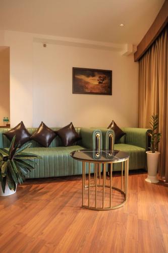 a living room with a green couch and a table at Hotel Sky Sierra Wayanad in Kalpetta