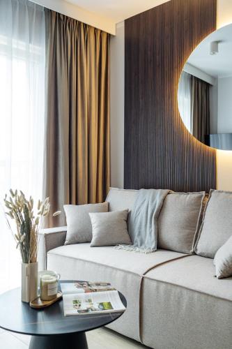 a living room with a couch and a table at Muse - LoftAffair Spa Collection in Kraków