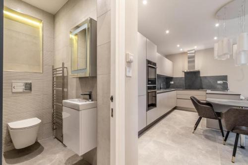 een keuken met een toilet, een wastafel en een tafel bij Beautiful 1-Bed Apartment in Golders Green London in Londen