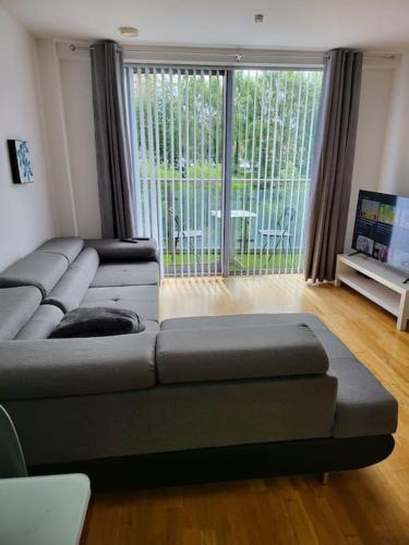a living room with a couch and a large window at Elegant City Centre Flat in Leeds