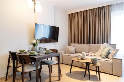 a living room with a table and a couch at Muse - LoftAffair Spa Collection in Kraków