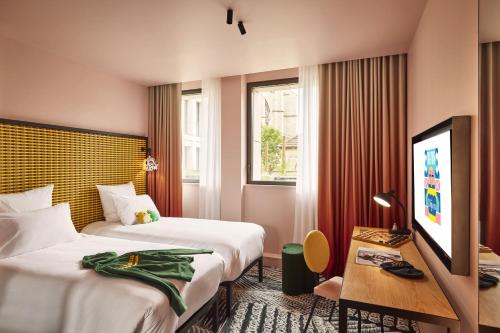 um quarto de hotel com duas camas e uma televisão de ecrã plano em Mama Shelter Dijon em Dijon