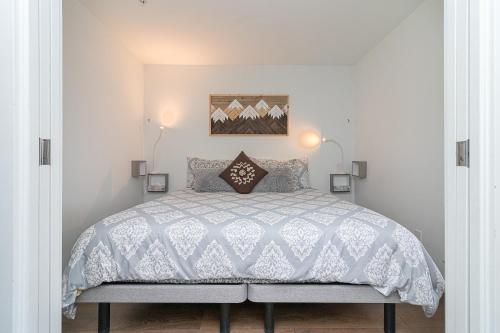 a bedroom with a bed with a white comforter at Chinatown Chic Suite by Iris Properties! in Victoria