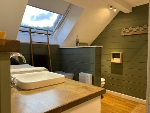 een badkamer met een wastafel op een aanrecht met een raam bij Le repos du Wayai in Theux