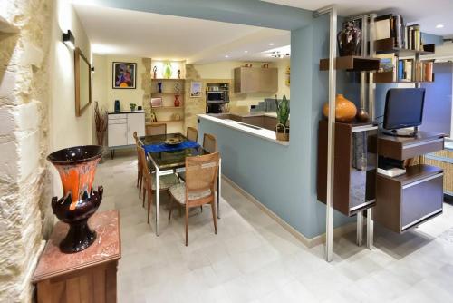 a kitchen and dining room with a table and chairs at Charmante maison de village au coeur du Luberon in Cucuron