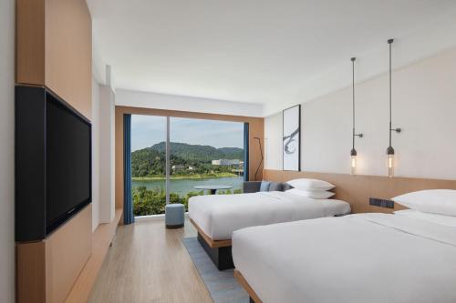 長沙市にあるFairfield by Marriott Changsha Yueluのベッド2台と薄型テレビ付きのホテルの部屋