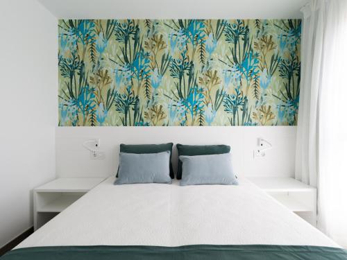 una camera da letto con un letto e carta da parati floreale di Zeus By CanariasGetaway a Telde