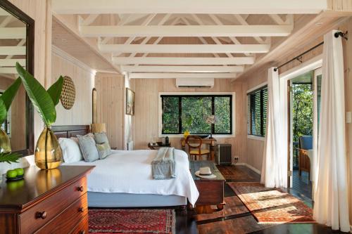 a bedroom with a bed and a large window at Prana Lodge in Chintsa