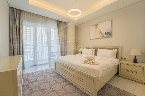 a bedroom with a bed and a large window at KeyHost - 1BR Apartment Near Five Hotel JVC - K141 in Dubai