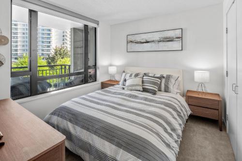 a bedroom with a bed and a large window at Astoria Elegance by Iris Properties in Victoria