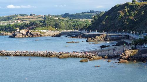 a group of people on a beach near the water at Sofia´s Canto del Mar in Candás