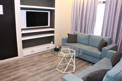 a living room with a couch and a tv at Beverly Hotel Beirut in Beirut