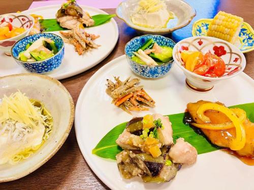 uma mesa com pratos e tigelas de comida em 幡谷温泉 ささの湯 em Hataya