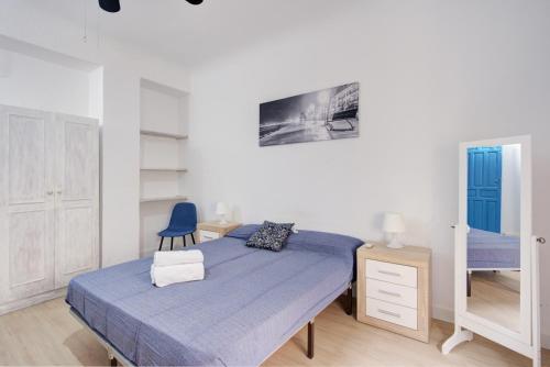 - une chambre avec un lit et une chaise bleue dans l'établissement New Arab Baths Apartament, à Grenade