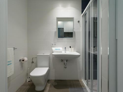 La salle de bains blanche est pourvue de toilettes et d'un lavabo. dans l'établissement Poseidon By CanariasGetaway, à Telde