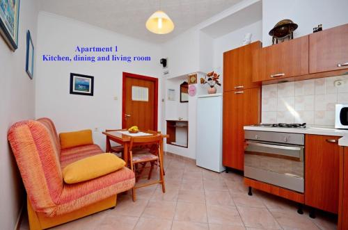 cocina con mesa y silla en una habitación en Apartments Best Location, en Supetar