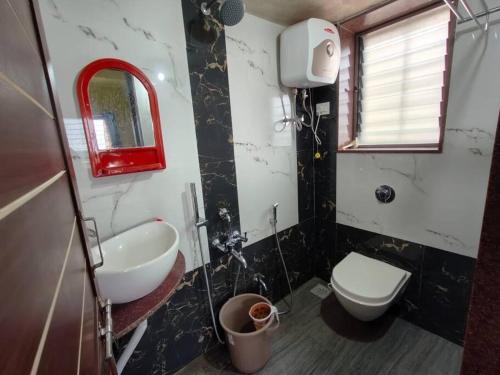a bathroom with a sink and a toilet and a mirror at Suite with valley view Panhala Fort in Panhāla