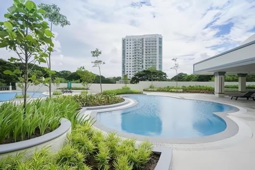a swimming pool in a resort with a building in the background at Casa de Vacaciones in Manila