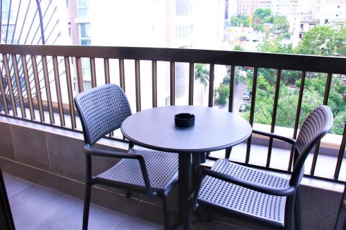 a table and two chairs on a balcony with a coffee cup at Beverly Hotel Beirut in Beirut