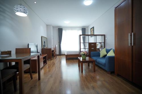 胡志明市的住宿－Lancaster Lê Thánh Tôn，客厅配有蓝色的沙发和桌子