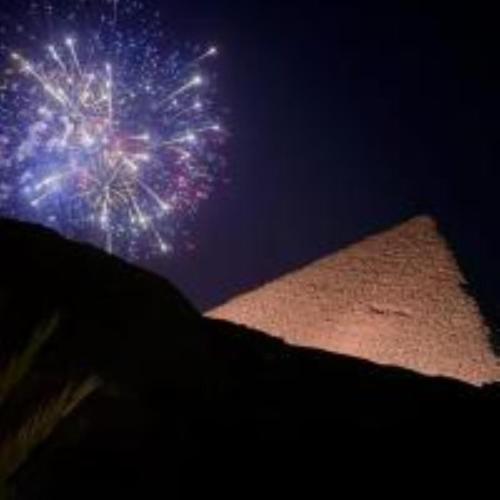 a firework exploding in the sky over a field at Crystal pyramid inn in Cairo
