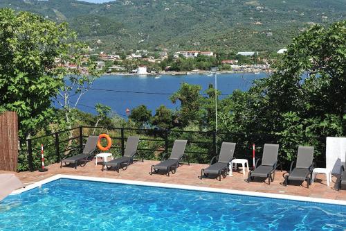 a swimming pool with chairs and a view of a lake at Anamar Skiathos Hotel in Punta
