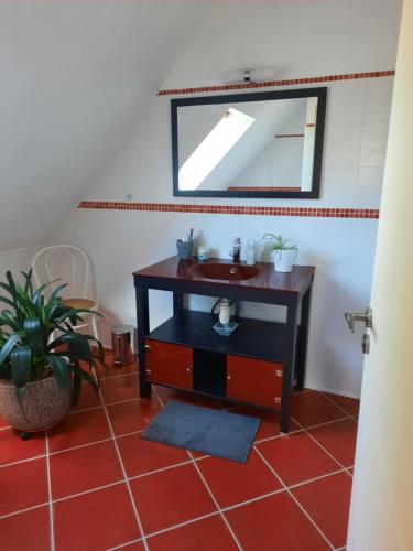 bagno con lavandino e specchio di Chambre à louer a Goven