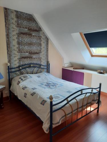 een slaapkamer met een bed met een bakstenen muur bij Chambre à louer in Goven