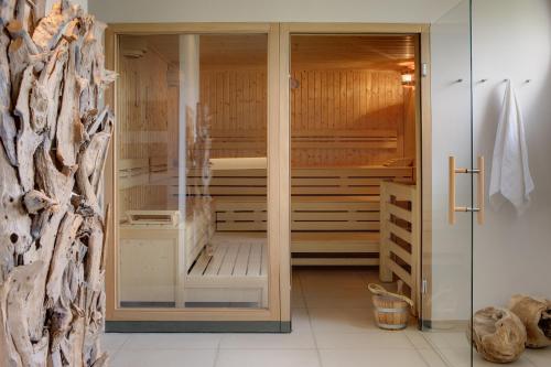 a walk in shower in a bathroom with wooden walls at Welcome Hotel Wesel in Wesel