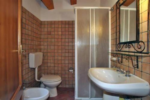 a bathroom with a sink and a toilet and a mirror at Casa Rosa 1 in Patti