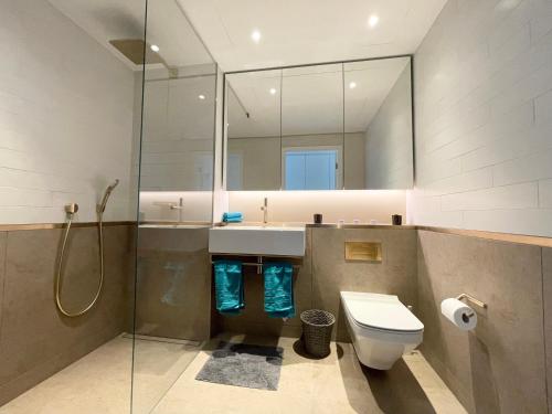 a bathroom with a sink and a toilet and a mirror at Battersea Power Apartments in London