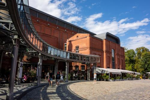 a large brick building with people walking in front of it at Apartamenty Browar Luxury Old Town Poznań 24h in Poznań