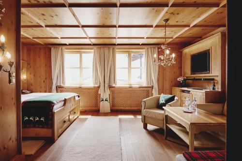 a bedroom with a bed and a couch and a table at Burg Hotel Oberlech in Lech am Arlberg