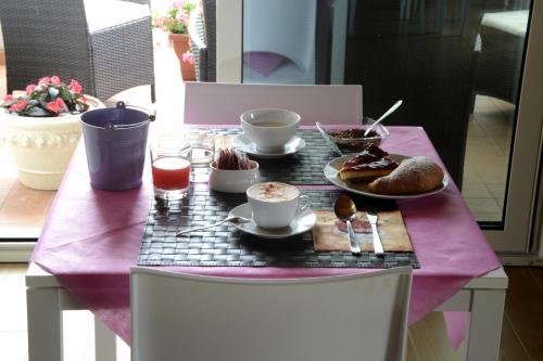 een tafel met eten en drinken op een paarse tafel bij B&B Carlotta in Montesilvano