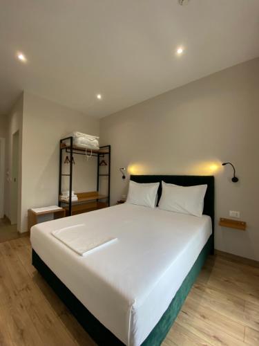 a bedroom with a large white bed with white pillows at Merly Hotel in Përmet