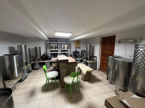 uma cozinha com cadeiras verdes e mesas num quarto em Sebe apartments 1 em Holíč
