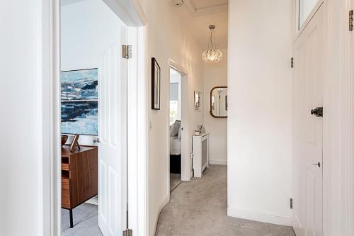 a hallway leading to a bathroom with a sink at Gorgeous Clapham Flat in London