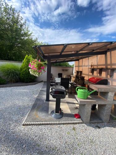a barbecue under a pavilion with a table and a grill at Sebe apartments 1 in Holíč