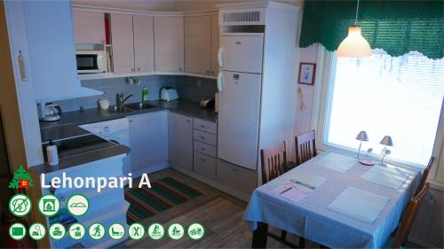 a kitchen with a table and a white refrigerator at Talo Ylläs in Äkäslompolo
