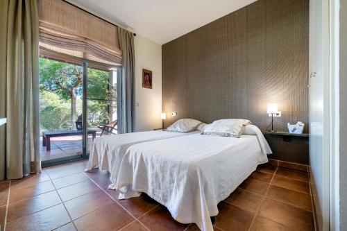 a bedroom with a bed and a large window at Villa Lux Ana in L'Ametlla de Mar