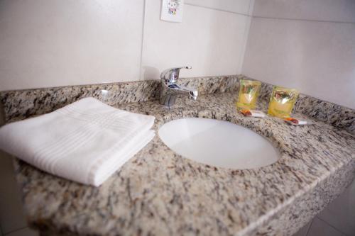 a bathroom counter with a sink and two glasses on it at Flex Hotel in Canoinhas
