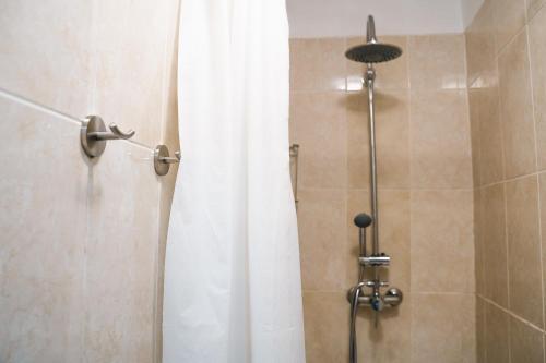 W łazience znajduje się prysznic z białą zasłoną prysznicową. w obiekcie Ocean Nomads Coworking w Aronie