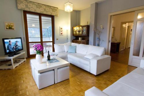 sala de estar con sofás blancos y TV en Connie's Apartment - Happy Rentals, en  Monvalle 
